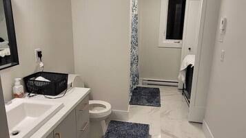 Chuveiro, toalhas de banho, sabonete, papel higiênico