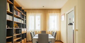 Ein Essbereich mit Tisch und Stühlen, einem Bücherregal und einer Katzensitznische an der Tür.