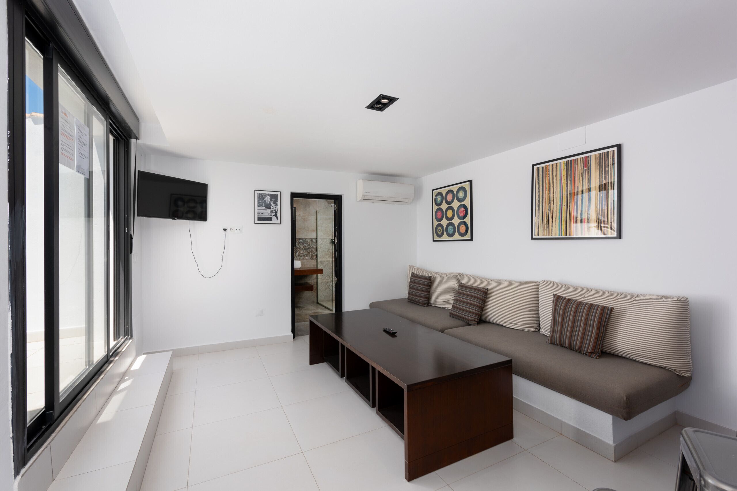 A modern living room with a sofa, a coffee table, and artwork on the walls.
