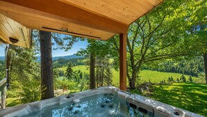 A hot tub under a wooden pergola with a view of a green landscape. - Stargaze | Views | Hot Tub | Dogs | BBQ | Firepit (Leavenworth)