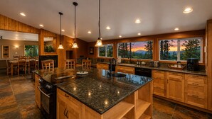 A spacious kitchen with granite countertops, wooden cabinets, and pendant lighting. - Stargaze | Views | Hot Tub | Dogs | BBQ | Firepit (Leavenworth)