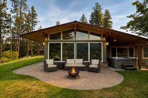 A modern outdoor patio with a fire pit, seating, and a hot tub. - Stargaze | Views | Hot Tub | Dogs | BBQ | Firepit (Leavenworth)