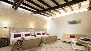 A hotel room with two beds, a sofa, a dining table, and a tiled floor. - Surrounded by the sea in Ortigia vacation home Syrakosia (Siracusa)