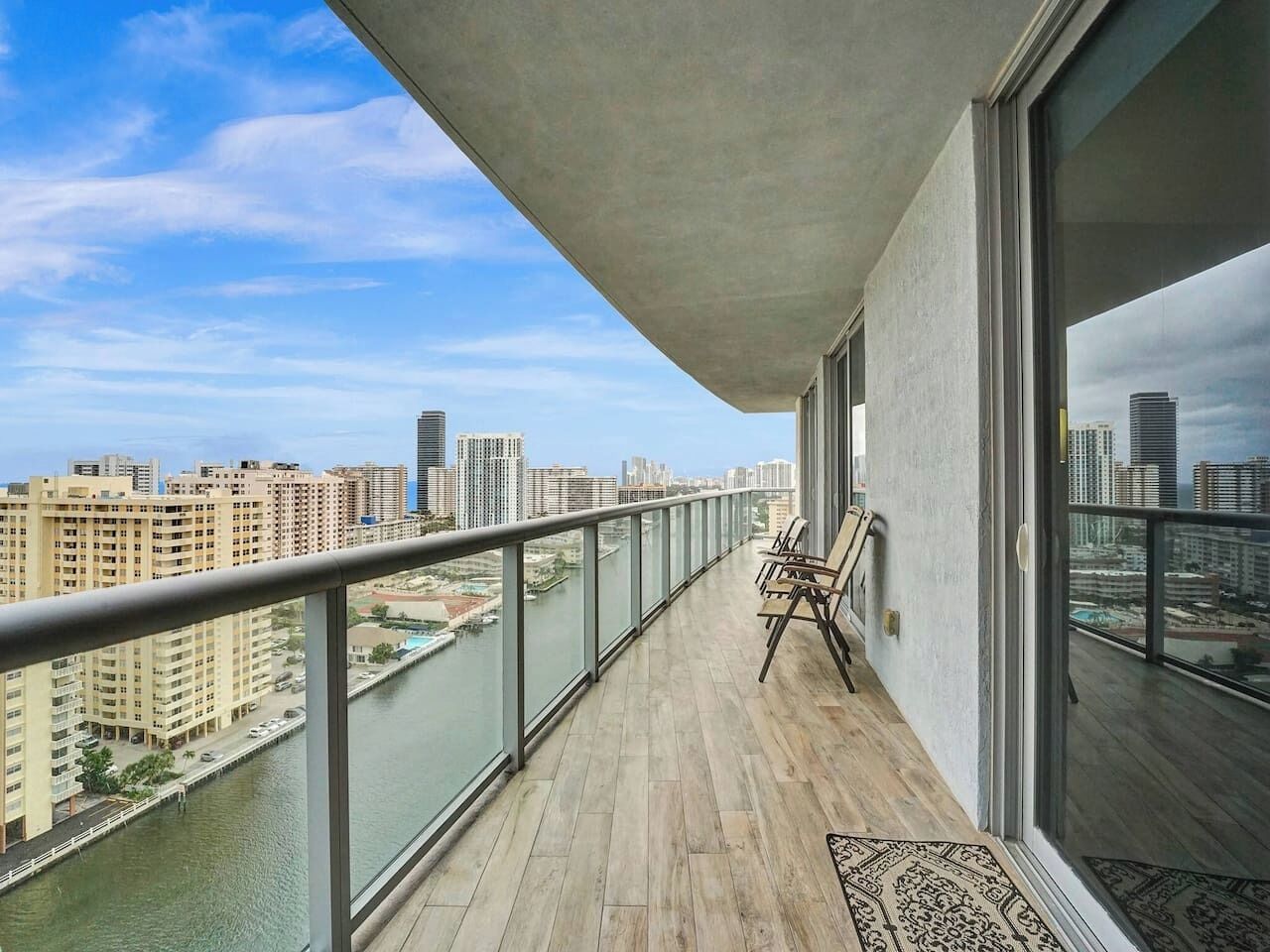A balcony with a view of a river and cityscape.