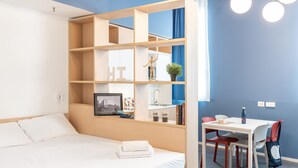A modern room with a bed, a desk with a chair, a bookshelf, and a window with curtains. - aparto Milan Ripamonti (Milan)