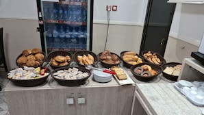 A buffet with various food items including pastries, bread, and sandwiches. - Samir Hotel (Algiers)