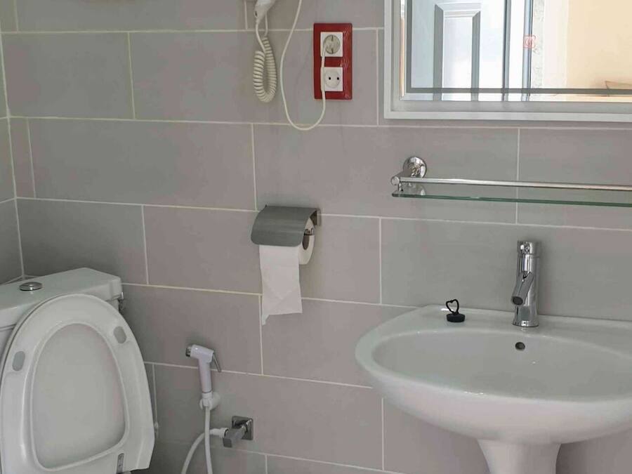 Un baño con inodoro, lavabo y espejo.