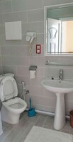 Un baño con inodoro, lavabo y espejo.