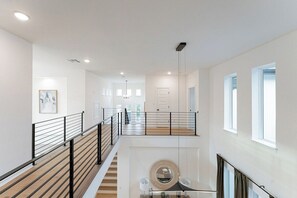 Ein modernes Interieur mit einer Treppe, einem runden Spiegel und einer Tür.