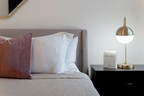 A neatly made bed with a grey headboard, a bedside lamp, and a sign reading 'Sleep Well.' - Scenic Hollows Escape with Trails & Outdoor Fun (Jonestown)