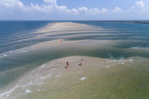 A beach with clear water and a wide sandy area.