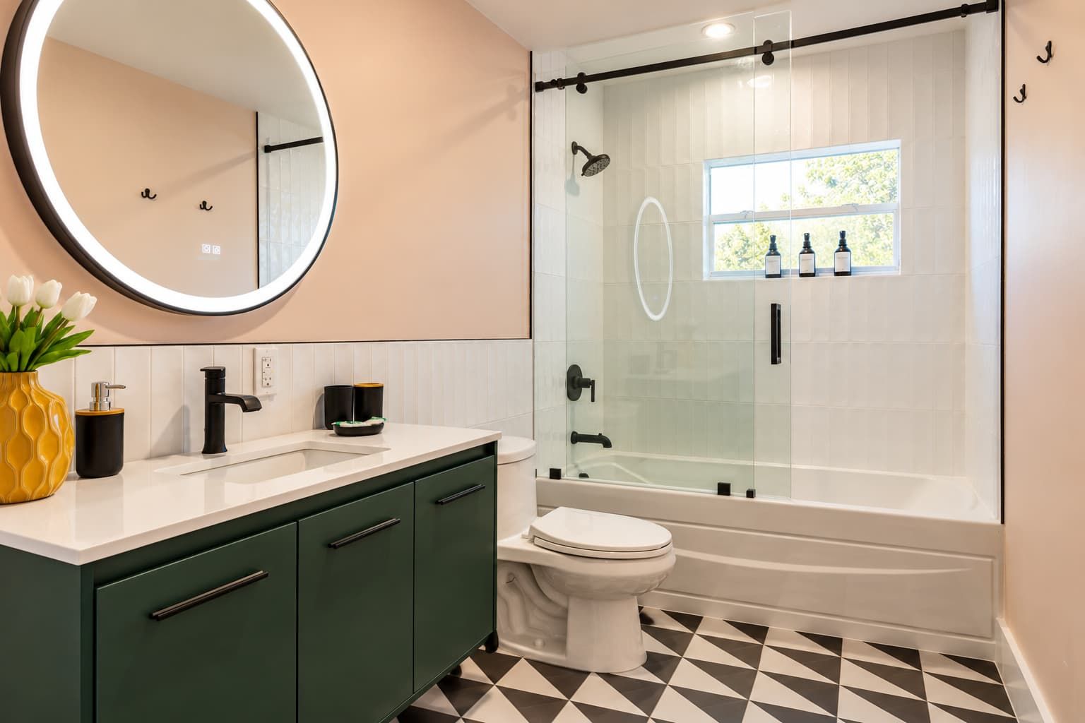 Een moderne badkamer met een douche met glazen wand, een wit toilet en een wastafel met spiegel.