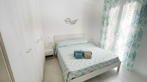 Une chambre à coucher avec un lit, une table de chevet et une fenêtre avec des rideaux.