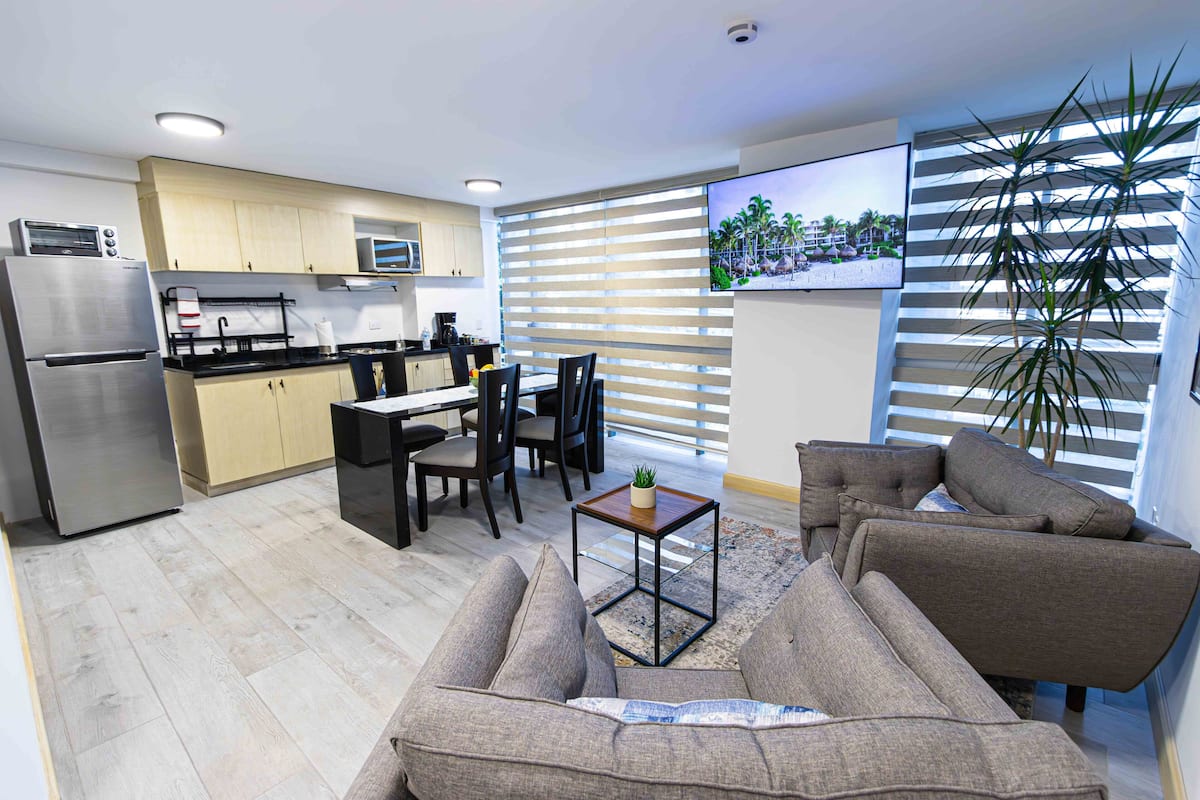 A modern kitchen with a refrigerator, microwave, and dining area.
