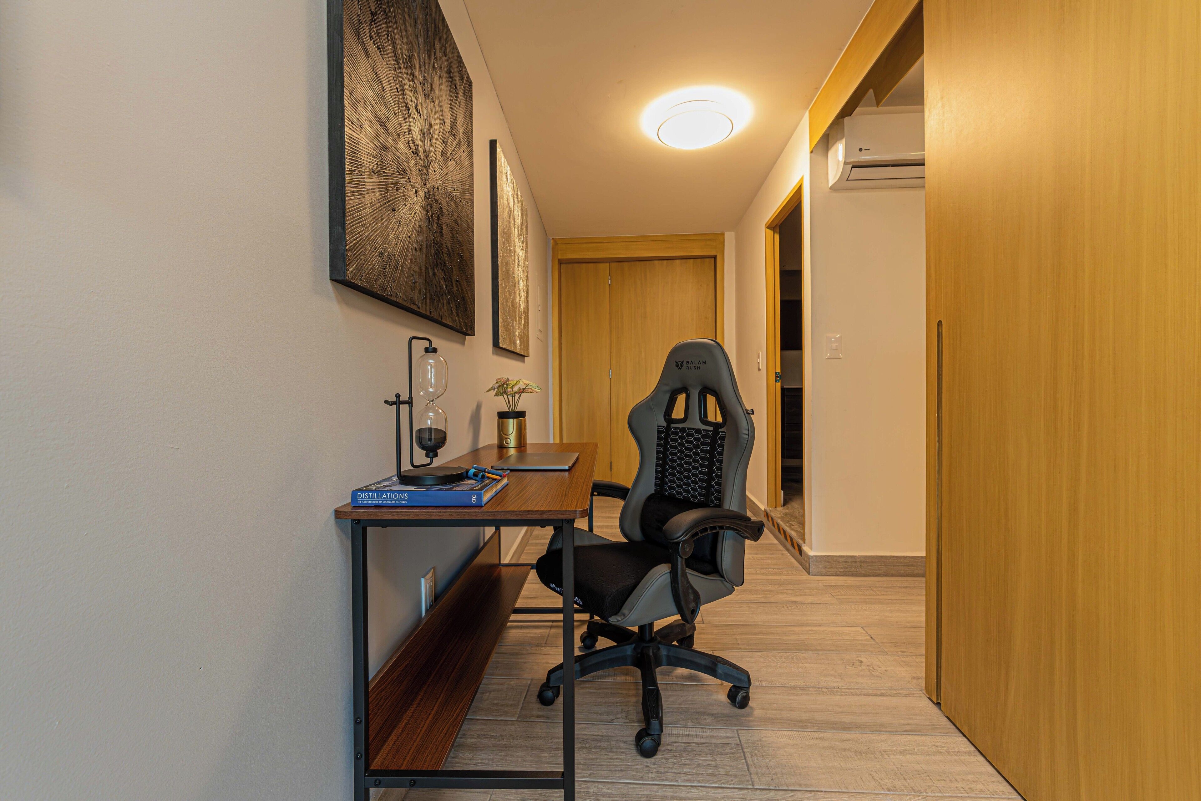 A modern office space with a desk, chair, and a bookshelf.