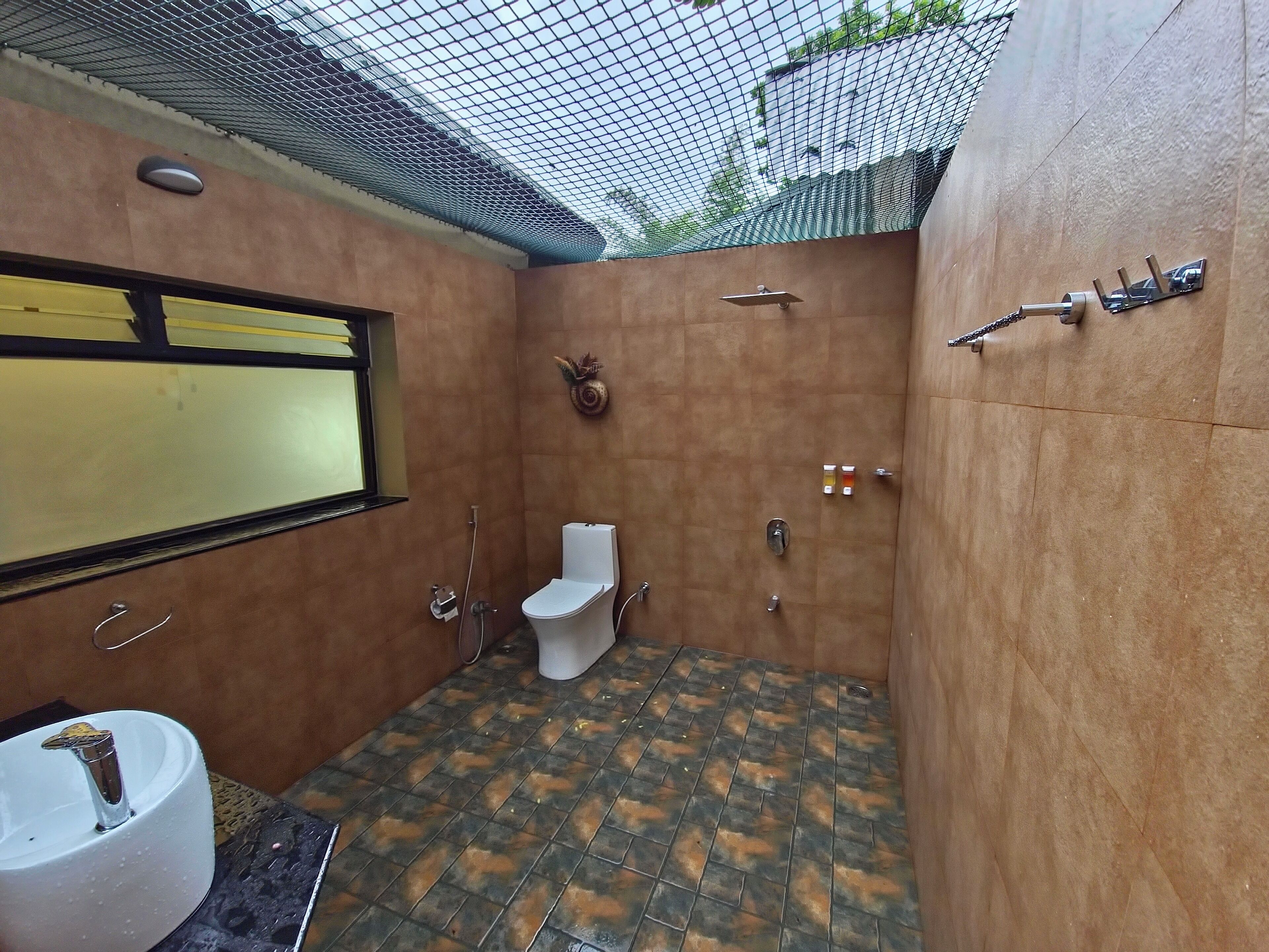 Un baño pequeño y cerrado con inodoro, lavamanos y ducha.
