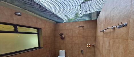 Un baño pequeño y cerrado con inodoro, lavamanos y ducha.