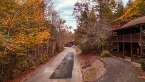 Un sentier menant à un chalet en bois, entouré d’un feuillage automnal.