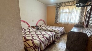 A room with two beds, a ceiling fan, a TV, and a window with curtains. - Hotel Mezvall (Morelia)