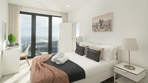 Une chambre d’hôtel moderne avec un grand lit, un bureau et une vue sur la ville.