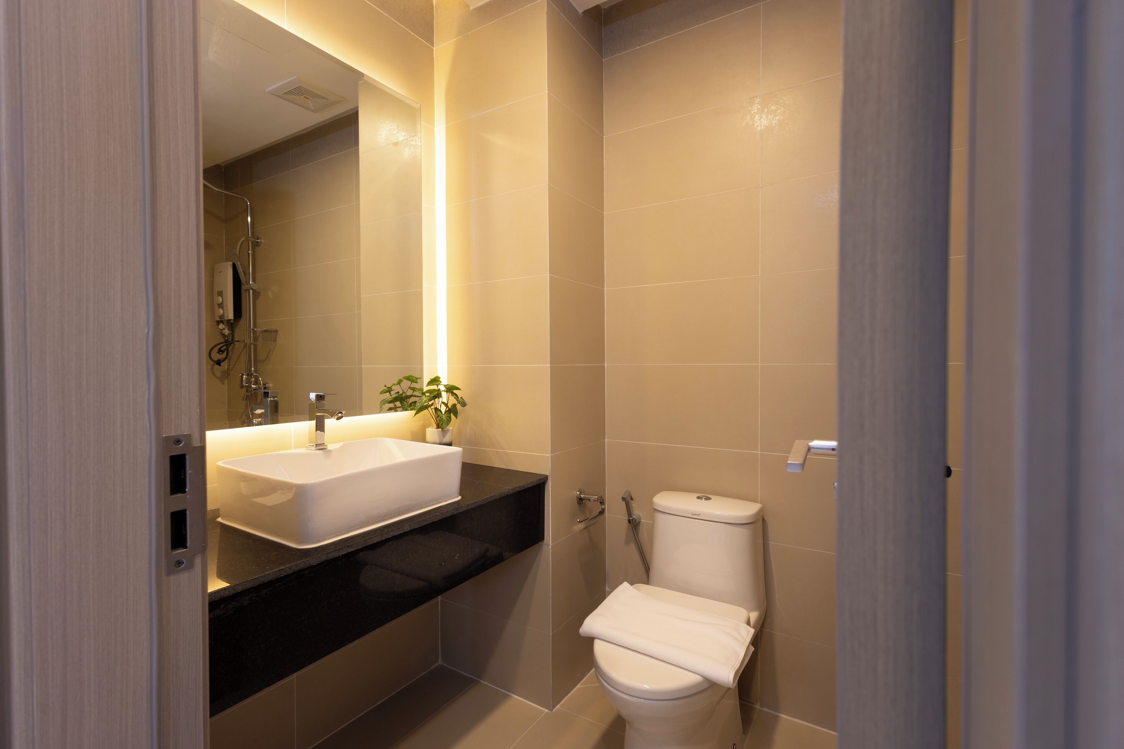 Un bagno moderno con un lavandino capiente, un WC e una doccia.