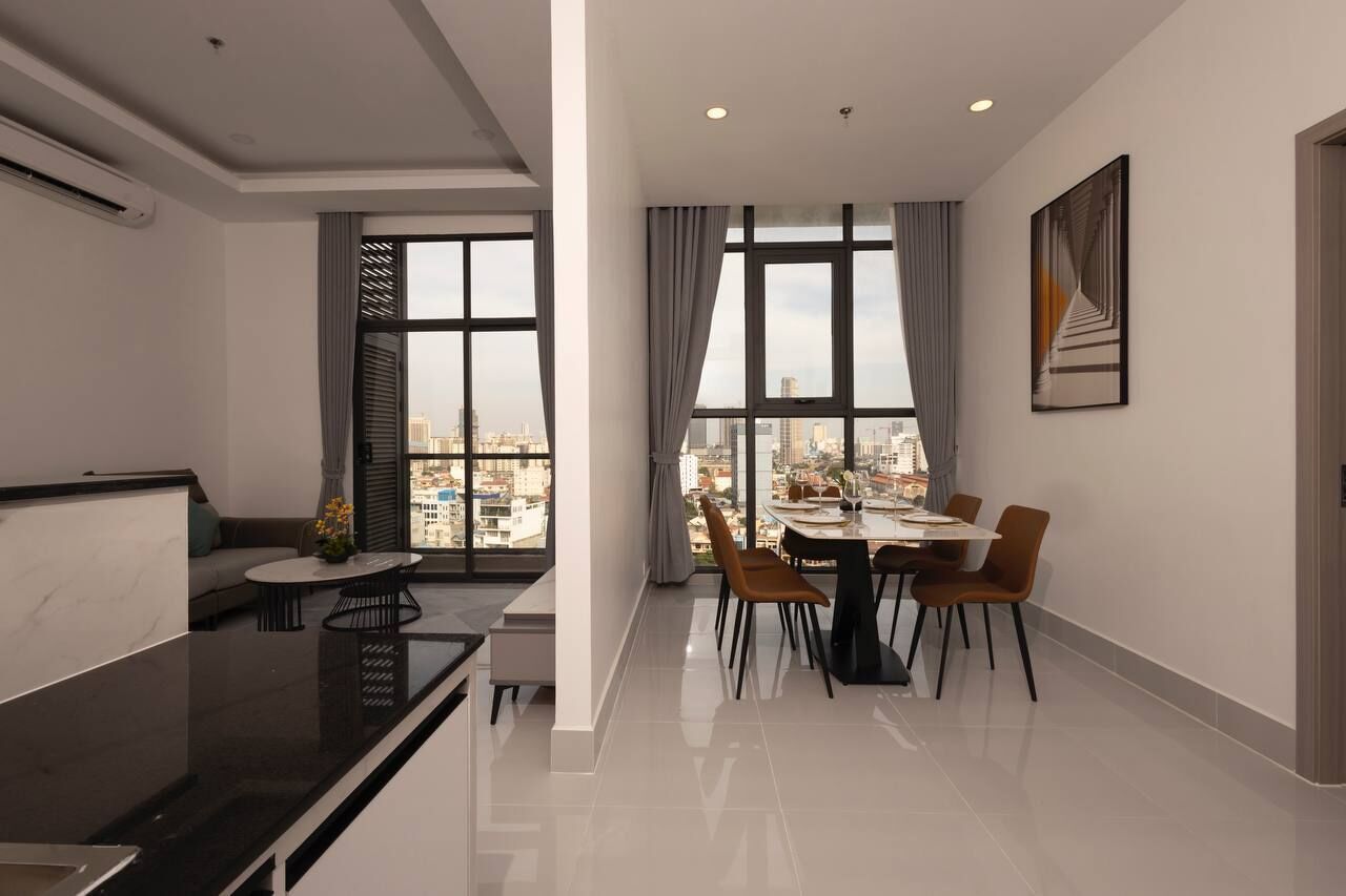Un espacio habitable moderno con comedor, ventanas amplias y vista a la ciudad.