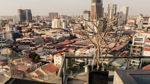 A cityscape view from a high vantage point, including a staircase leading to a balcony with a potted plant. - La Cozii TK (Phnom Penh)