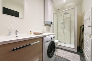 Chuveiro, toalhas de banho, sabonete, shampoo