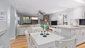 A modern living space with a dining area, kitchen, and a stone fireplace. - Pickleball, Pools, Internet, Free Parking, Paradise (Phoenix)