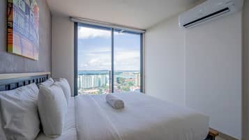 Quarto de hotel com uma cama grande, vista para a cidade e ar condicionado.