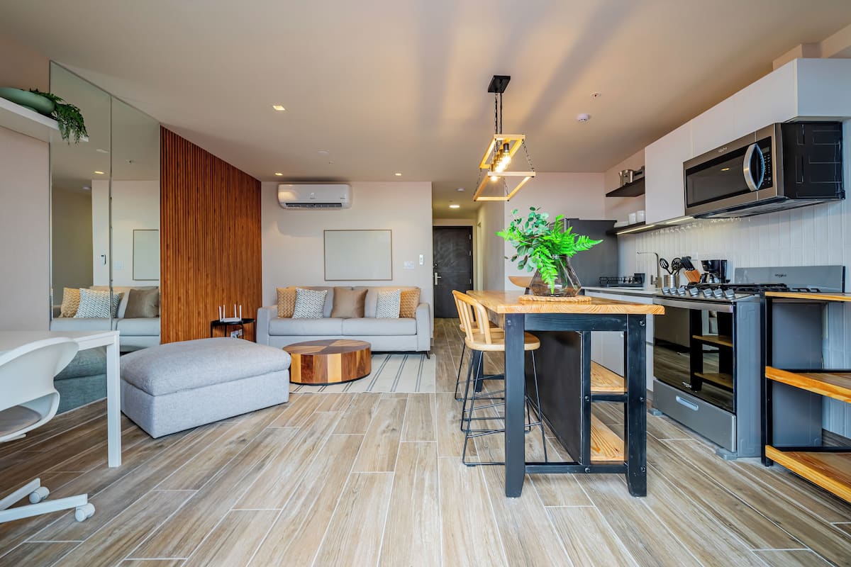 A modern kitchen with a dining area, a sofa, and a coffee table.