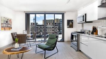 En moderne lejlighed med balkon, spiseområde og køkken.