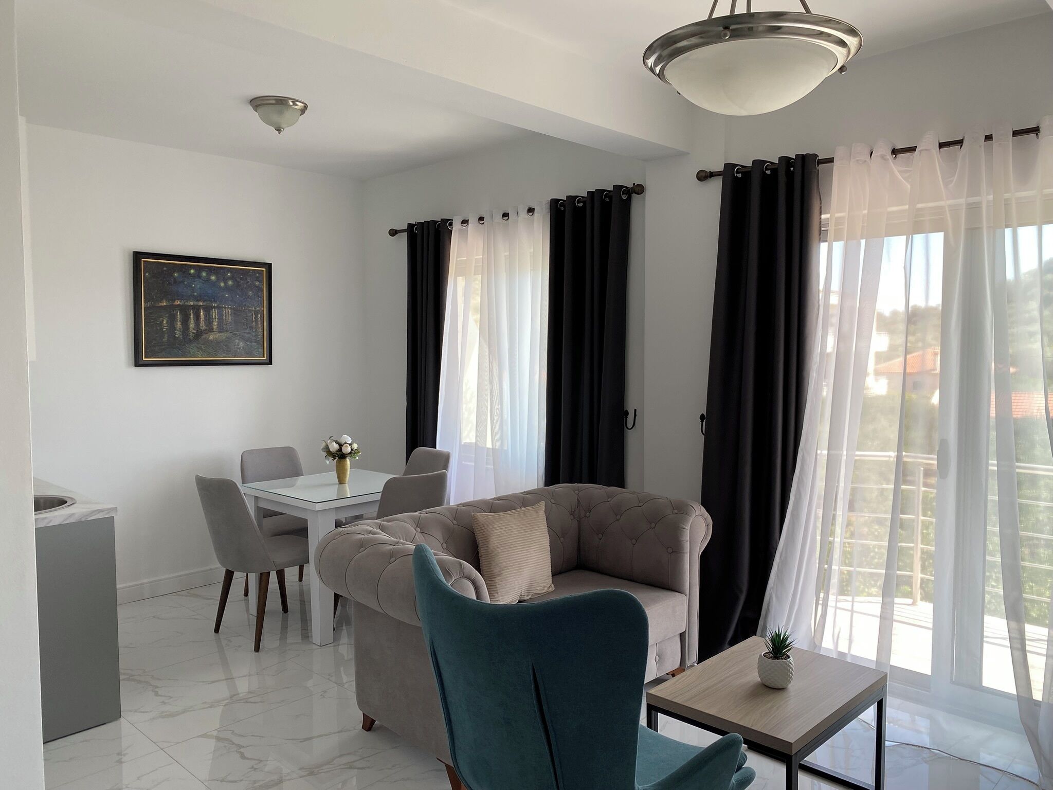 Een moderne woonkamer met een bank, stoelen, een bijzettafeltje en een eethoek.