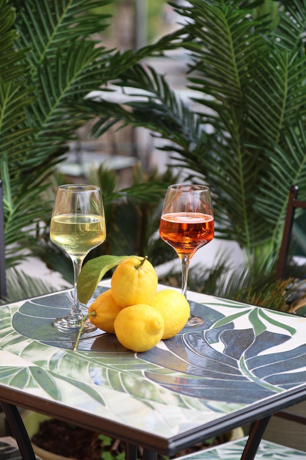 Una mesa con dos copas de vino y limones.