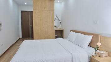 Un dormitorio con una cama grande, armario de madera, mesita de noche y una lámpara de noche pequeña.