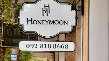 Un escaparate con un cartel que dice "HONEYMOON" y un número de teléfono "092 818 8668".