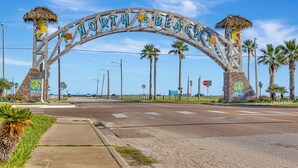 A large wooden archway with the words "North Beach" and tropical decorations. - Lighthouse at the beach (Corpus Christi)
