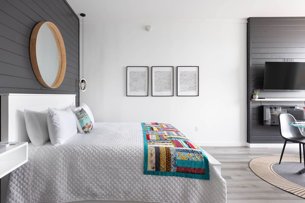 Un dormitorio moderno con una cama grande, un televisor y un escritorio.