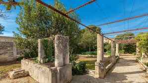 A courtyard with stone columns, a pergola, and a gravel path. - Villa Donna Linda by BarbarHouse (Taviano)