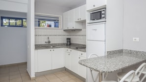 A compact kitchen with white cabinets, a microwave, and a coffee maker. - Alsol Los Caribes 1 (San Bartolomé de Tirajana)