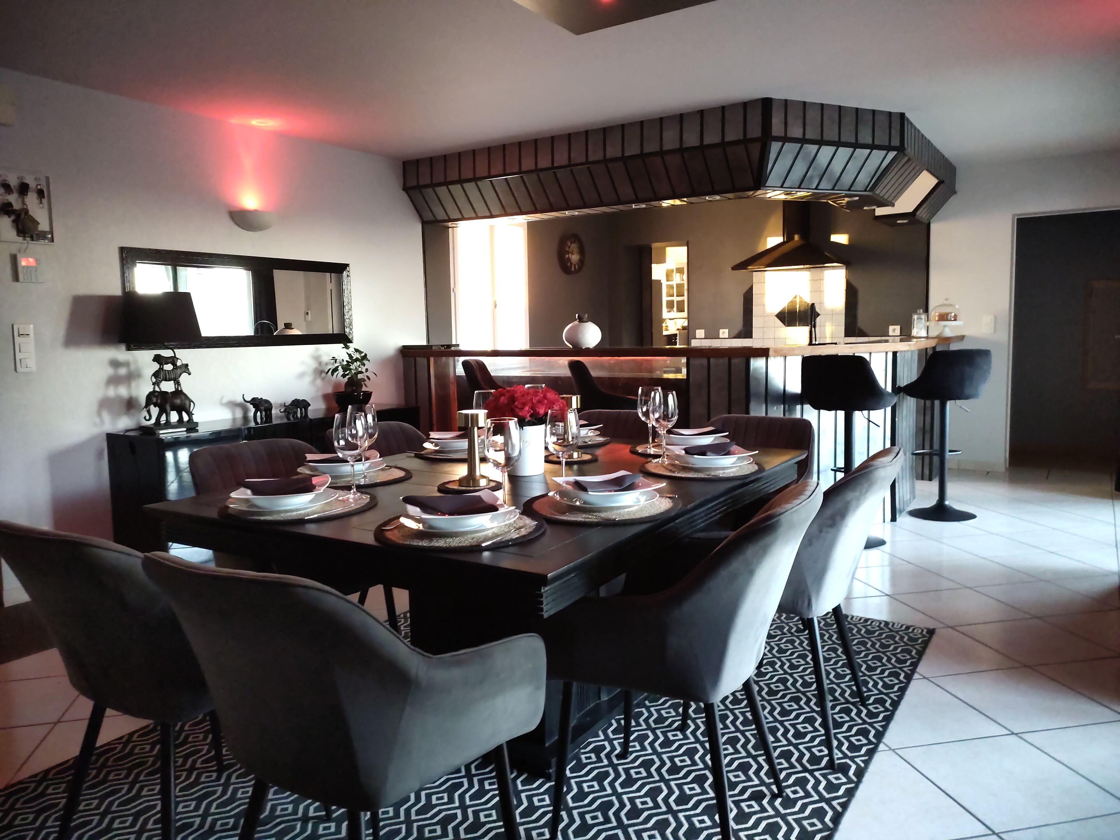 A modern dining area with a rectangular table set for four, surrounded by chairs.