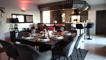 A modern dining area with a rectangular table set for four, surrounded by chairs.