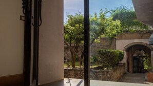 Una habitació amb una finestra gran, una porta i un sòl de rajoles.