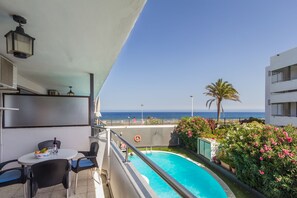 A balcony with a pool, outdoor seating, and a view of the sea. - Alsol Don Palomón (San Bartolomé de Tirajana)