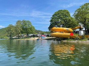 A water park with large yellow slides and a boat docked nearby.