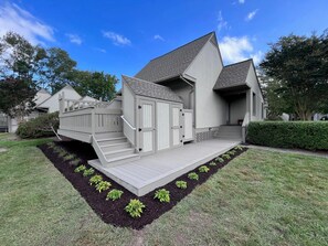 A modern two-story house with a covered porch and a small deck. - Lakefront Sea Colony Villa! Amenity Rich with Private Beach and Shuttle! (Bethany Beach)