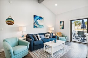 A modern living room with a sofa, armchairs, a coffee table, and artwork on the walls.
