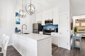A modern kitchen with white cabinetry, stainless steel appliances, and a central island. - Lakefront Sea Colony Villa! Amenity Rich with Private Beach and Shuttle! (Bethany Beach)