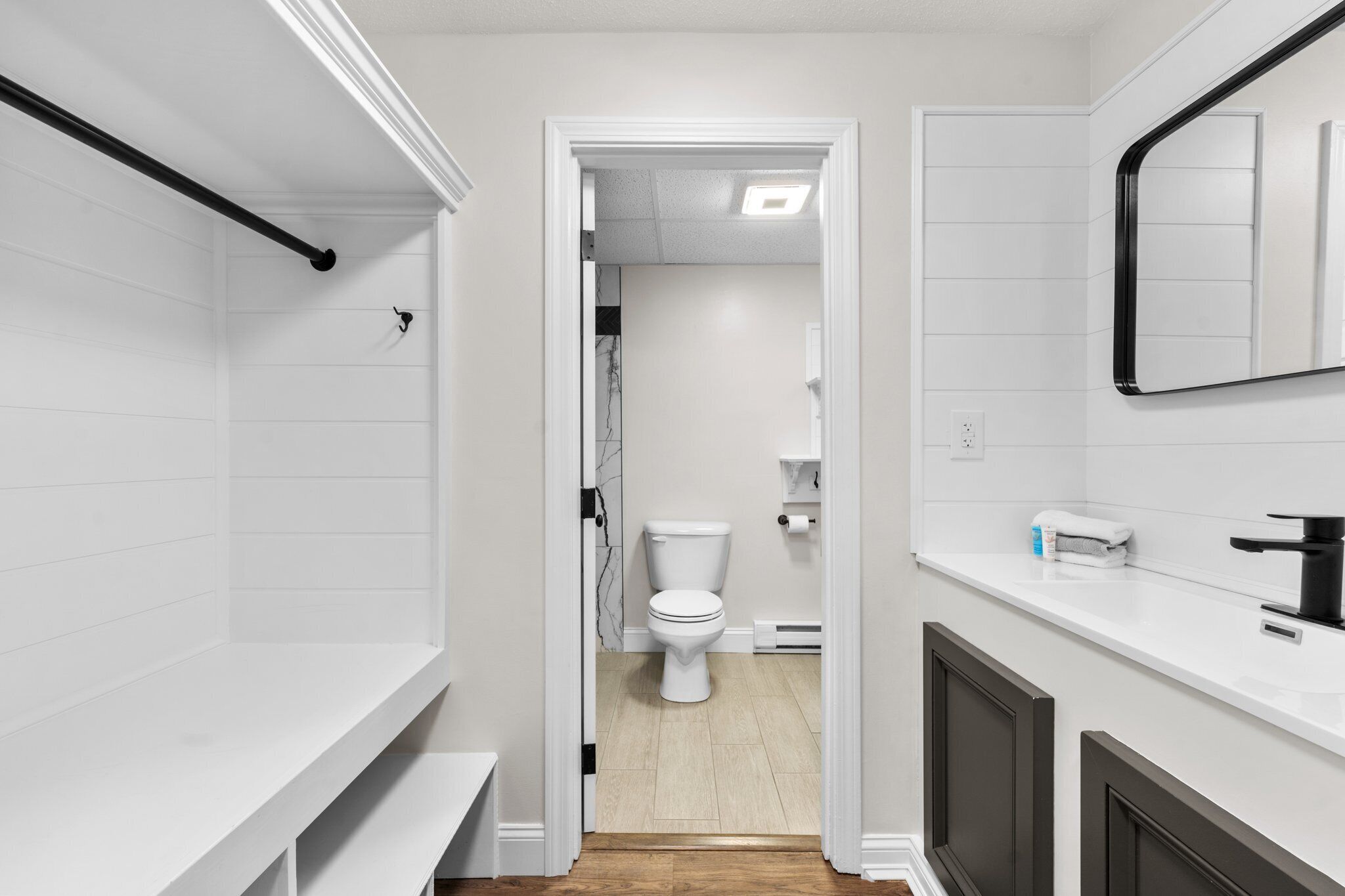 A modern bathroom with a toilet, sink, and mirror.