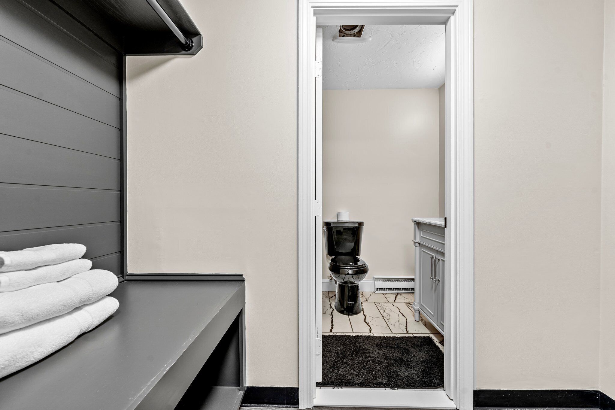 Un baño con inodoro, lavamanos y toallero.